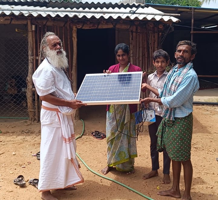 Sri Rama Rajanna Swamy Ji handing over a solar panel to a rural family — near AP and Karnataka border